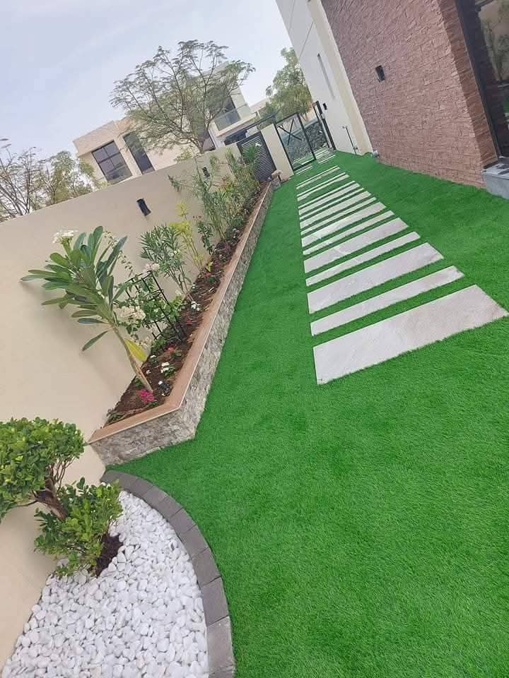 Stepping stones through artificial turf beside a raised planter